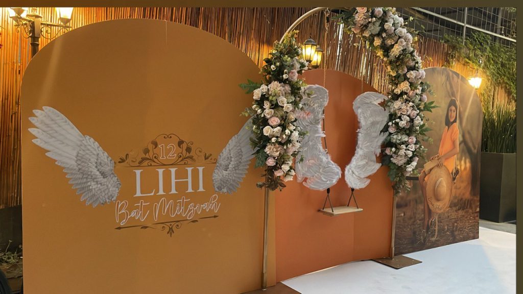 עיצוב קיר צילום בת מצווה קשתות פרחים נדנדה כנפיים